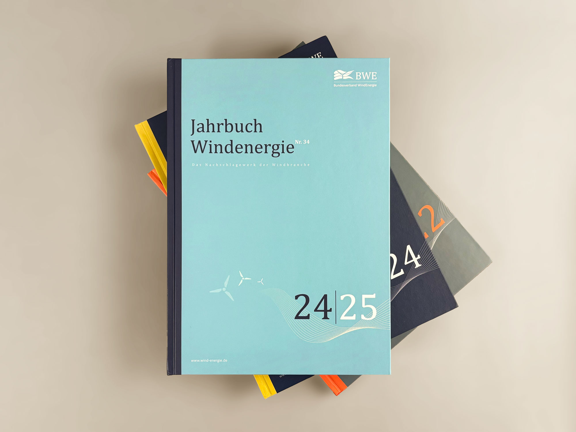 Drei Ausgaben des Jahrbuch Windernergie liegen gestapelt übereinander.