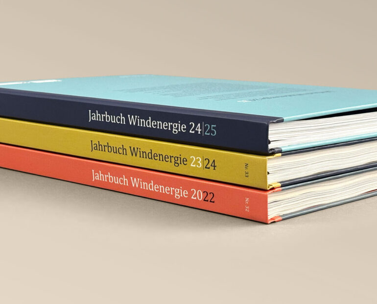 Drei Ausgaben des Jahrbuch Windernergie liegen gestapelt übereinander.