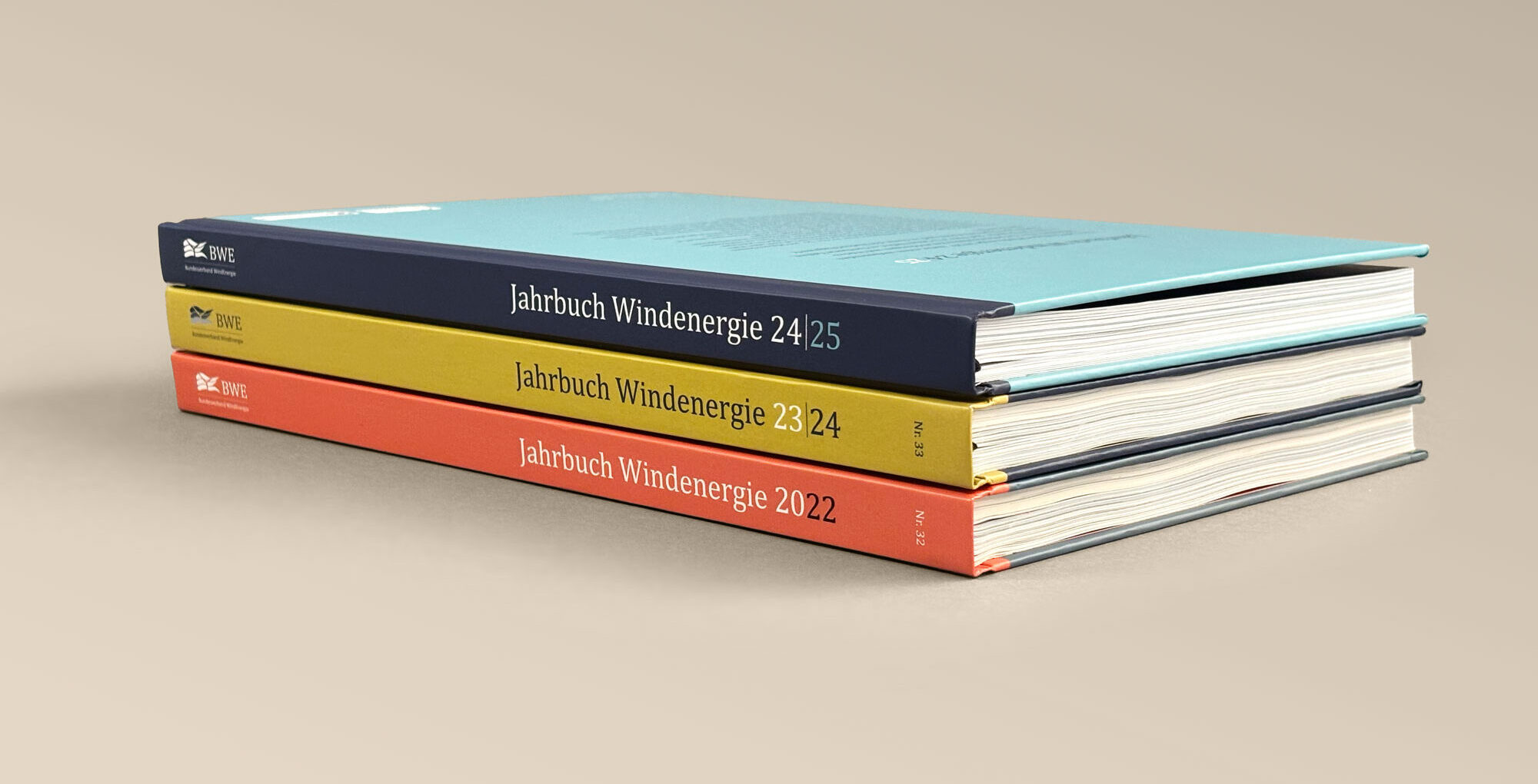 Drei Ausgaben des Jahrbuch Windernergie liegen gestapelt übereinander.